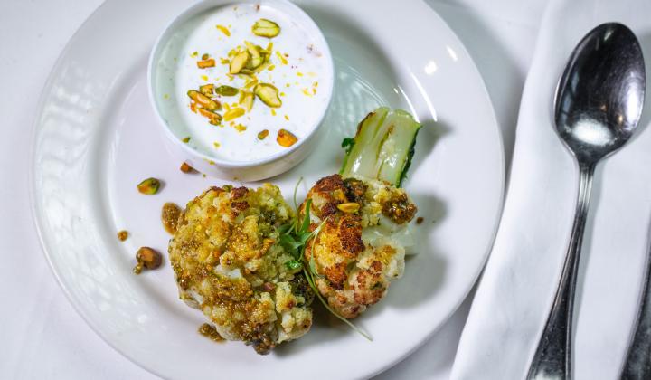 Chou-fleur entier rôti au crumble de pistache et crème fraîche à l’oignon vert